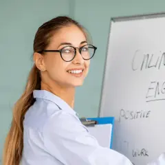 Glad lärare skriver "English Lesson" på en whiteboard. Perfekt för din engelska kurs distans.