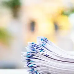 En hög med papper, organiserad med blå gem, som representerar vikten av att följa artikel 30 GDPR för dataskydd.