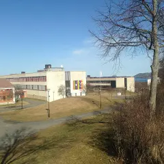 Sanda gymnasiet med sina moderna byggnader och grönområden, en solig dag.
