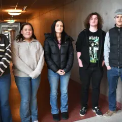 Fem elever från estetiska skolan Arvika står i en korridor.