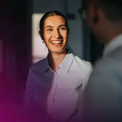 En kvinna ler och pratar med en kollega. Deras samtal kan leda till ett muntligt avtal bindande.