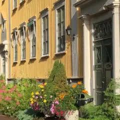 En gul träbyggnad med blommor framför, en del av stora segerstad naturbrukscentrum.