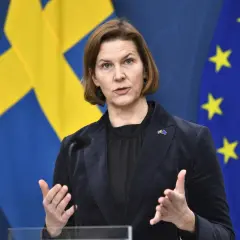 Kvinnlig talare framför svenska och EU-flaggor, diskuterar direkt effekt EU.