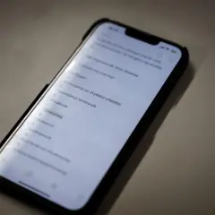 En mobiltelefon visar en lista med brott, inklusive "falsk tillvitelse". Listan kan vara en del av en juridisk process där skadestånd kan bli aktuellt.