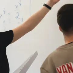 En elev på Realgymnasiet Uppsala pekar på en matematisk formel på tavlan.