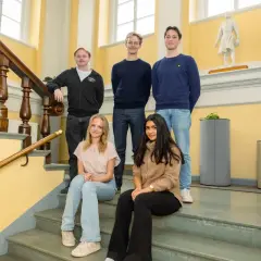 Fem elever poserar på en trappa vid Rudbeckianska gymnasiet.