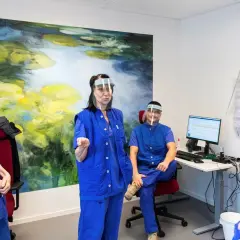 Personal med visir och blå kläder diskuterar gynekolog utbildning.