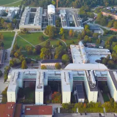 Stora universitetsbyggnader med gröna ytor och träd. En modern campusmiljö som visar en framgångsrik integration av ekonomi och IT.