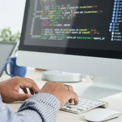Person skriver kod på en datorskärm, en del av datorteknik 1a.