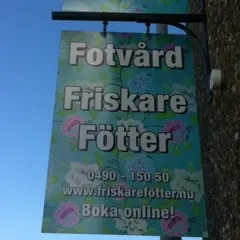 Skylt för "Fotvård Friskare Fötter" med blomstermönster. Erbjuder fotvård och fotvård utbildning. Boka online!