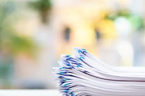 En hög med papper, organiserad med blå gem, som representerar vikten av att följa artikel 30 GDPR för dataskydd.