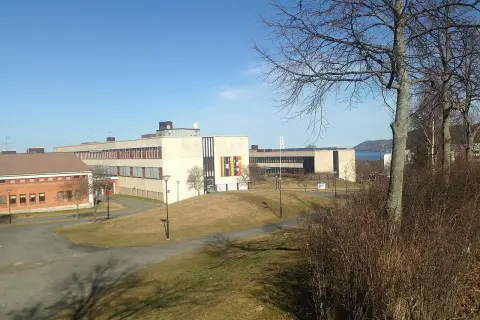 Sanda gymnasiet med sina moderna byggnader och grönområden, en solig dag.