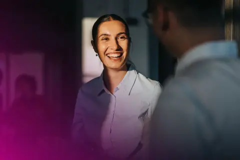 En kvinna ler och pratar med en kollega. Deras samtal kan leda till ett muntligt avtal bindande.
