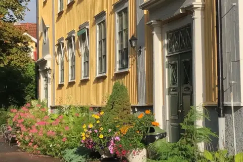 En gul träbyggnad med blommor framför, en del av stora segerstad naturbrukscentrum.