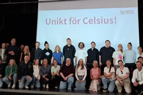 Gruppbild på personal och elever från Celsius skolan framför en projektorduk med texten "Unikt för Celsius!".