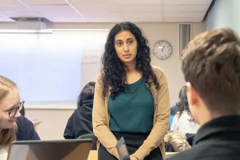 Lärare i en klassrumsmiljö på arena academy. Eleverna lyssnar uppmärksamt.