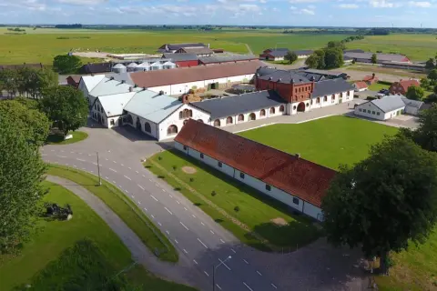 Ögonblicksbild över Bollerups lantbruksinstitut med sina många byggnader, gröna fält och träd.