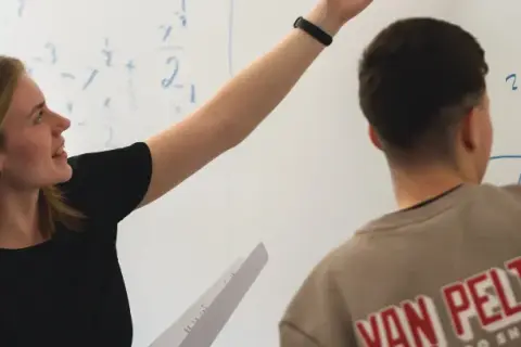 En elev på Realgymnasiet Uppsala pekar på en matematisk formel på tavlan.