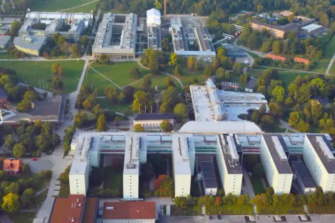 Stora universitetsbyggnader med gröna ytor och träd. En modern campusmiljö som visar en framgångsrik integration av ekonomi och IT.