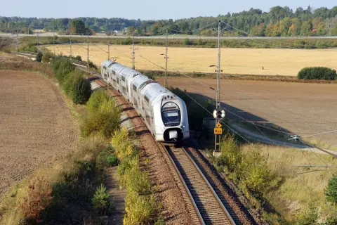 Ett modernt tåg susar fram på spåret genom höstlandskapet. Kanske är det här framtidens tågtekniker utbildning sker, med fokus på effektivitet och miljö.