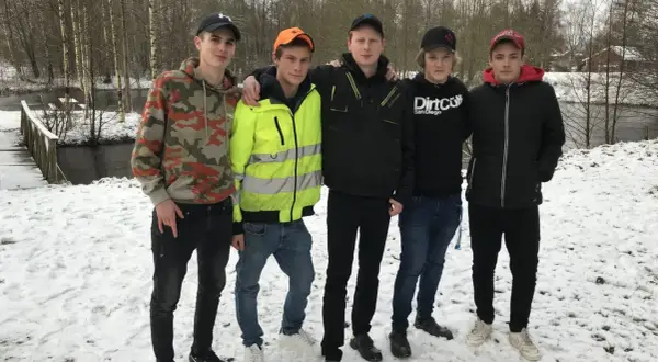 Fem killar från Ryssby gymnasiet poserar i snön vid en bro.