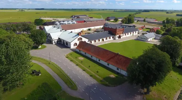Ögonblicksbild över Bollerups lantbruksinstitut med sina många byggnader, gröna fält och träd.