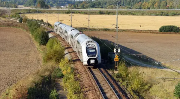Ett modernt tåg susar fram på spåret genom höstlandskapet. Kanske är det här framtidens tågtekniker utbildning sker, med fokus på effektivitet och miljö.