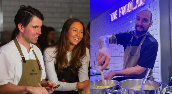 Två glada personer deltar i roliga kurser i matlagning. En man och en kvinna ler medan de lagar mat, och en kock med tatueringar rör i kastruller under neonskylten "THE FOODLAB".