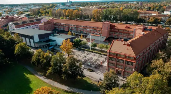Luftfoto över Virginska gymnasiet med sina tegelbyggnader och en stor cykelparkering. Hösten färgar träden gyllene.