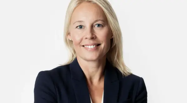 En kvinna med blont hår och blå ögon i mörk kavaj. Hon ler mot kameran, kanske efter att ha löst ett GDPR-incident.