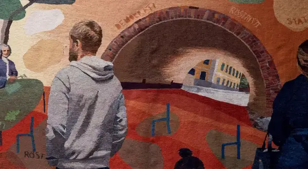 En vävd bild med människor och en valvbro. Kanske en scen från politices kandidatprogram Lund, med symboler för frihet och röster.