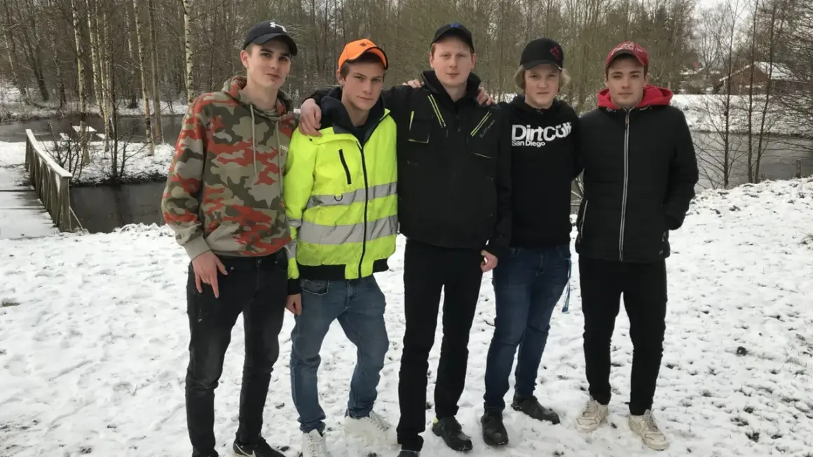 Fem killar från Ryssby gymnasiet poserar i snön vid en bro.