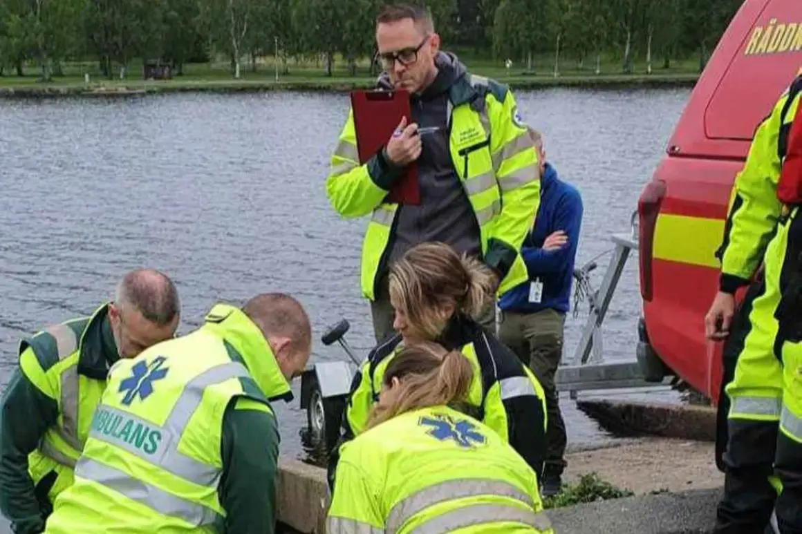 Ambulanssjukvårdare i utbildning distans övar vid vattnet. De bär reflexvästar och en instruktör antecknar.