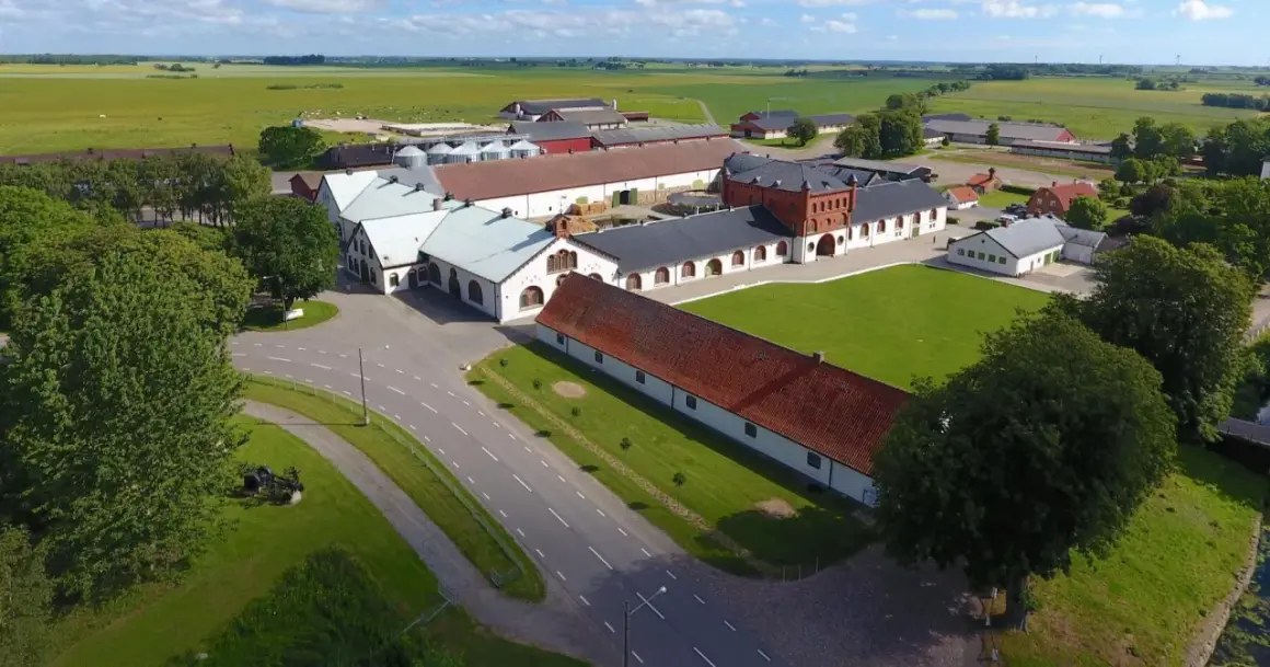 Ögonblicksbild över Bollerups lantbruksinstitut med sina många byggnader, gröna fält och träd.