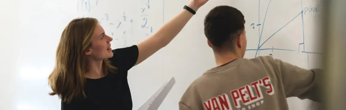 En elev på Realgymnasiet Uppsala pekar på en matematisk formel på tavlan.