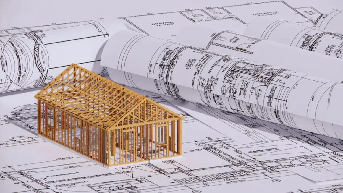 En trämodell av ett hus står på ritningar. En bra början för att förstå hur man blir arkitekt.