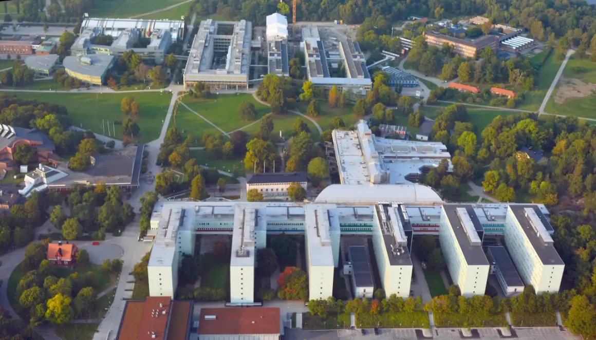 Stora universitetsbyggnader med gröna ytor och träd. En modern campusmiljö som visar en framgångsrik integration av ekonomi och IT.