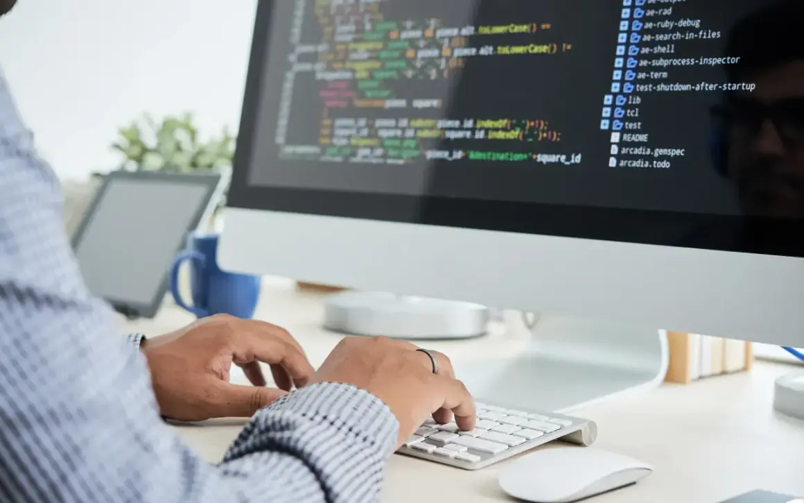 Person skriver kod på en datorskärm, en del av datorteknik 1a.
