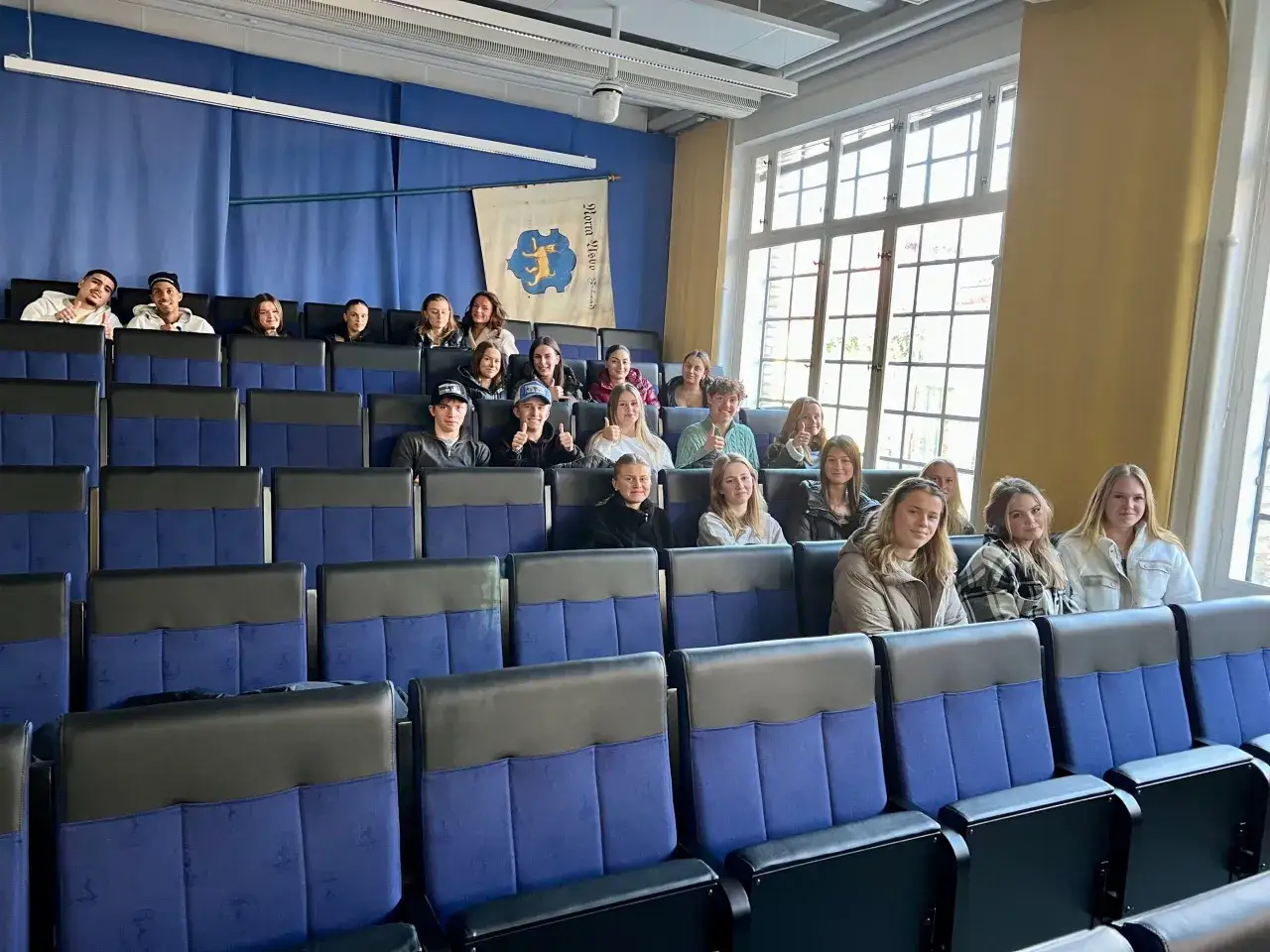 Studenter deltar i en utvidgad juridisk introduktionskurs. De sitter i en f&ouml;rel&auml;sningssal med bl&aring; stolar och en gul v&auml;gg.
