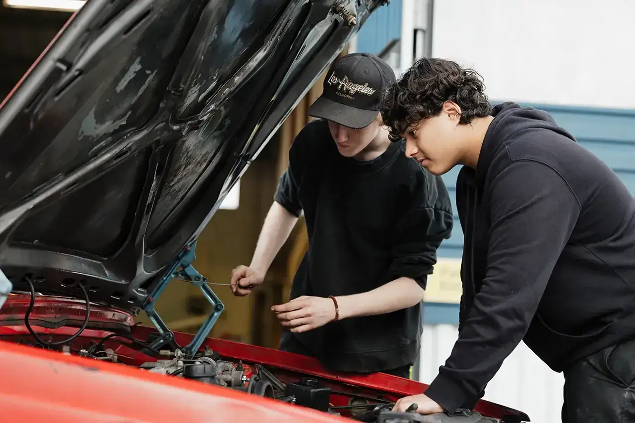 Tv&aring; elever p&aring; fordon och transportprogrammet unders&ouml;ker en bilmotor.