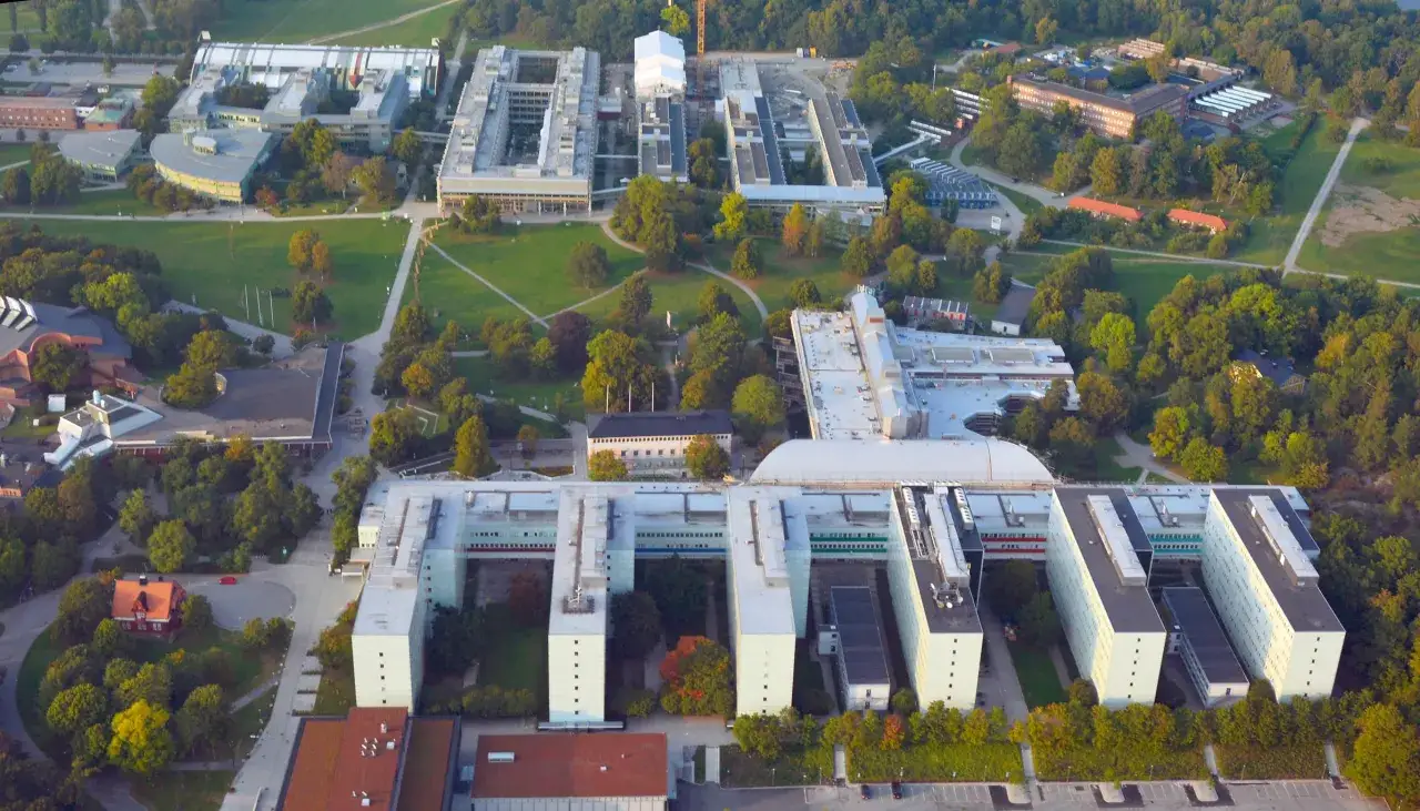 Stora universitetsbyggnader med gr&ouml;nomr&aring;den. En modern campusmilj&ouml; som visar hur ekonomi och IT samverkar i en akademisk milj&ouml;.