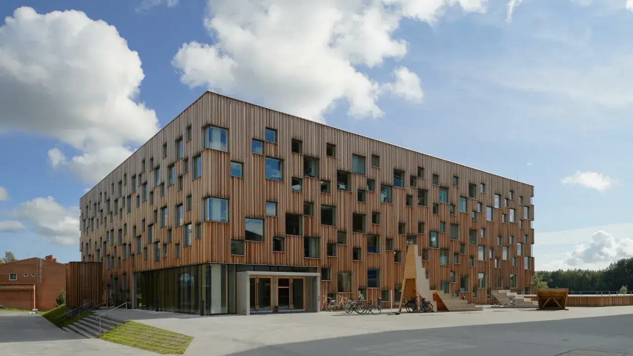 Modern träbyggnad med många fönster. Kanske en inspirationskälla för den som undrar hur blir man arkitekt.