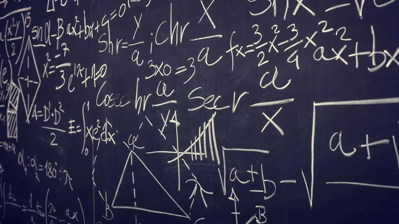 Svart tavla med komplexa matematiska formler och grafer, typiskt f&ouml;r fysik 1 komvux.