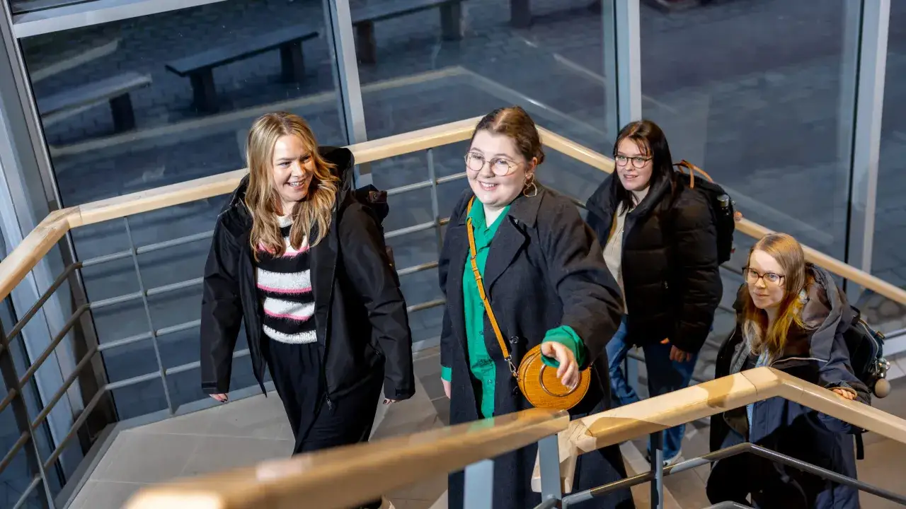Fyra glada studenter g&aring;r uppf&ouml;r trappan p&aring; campus Ljungby.