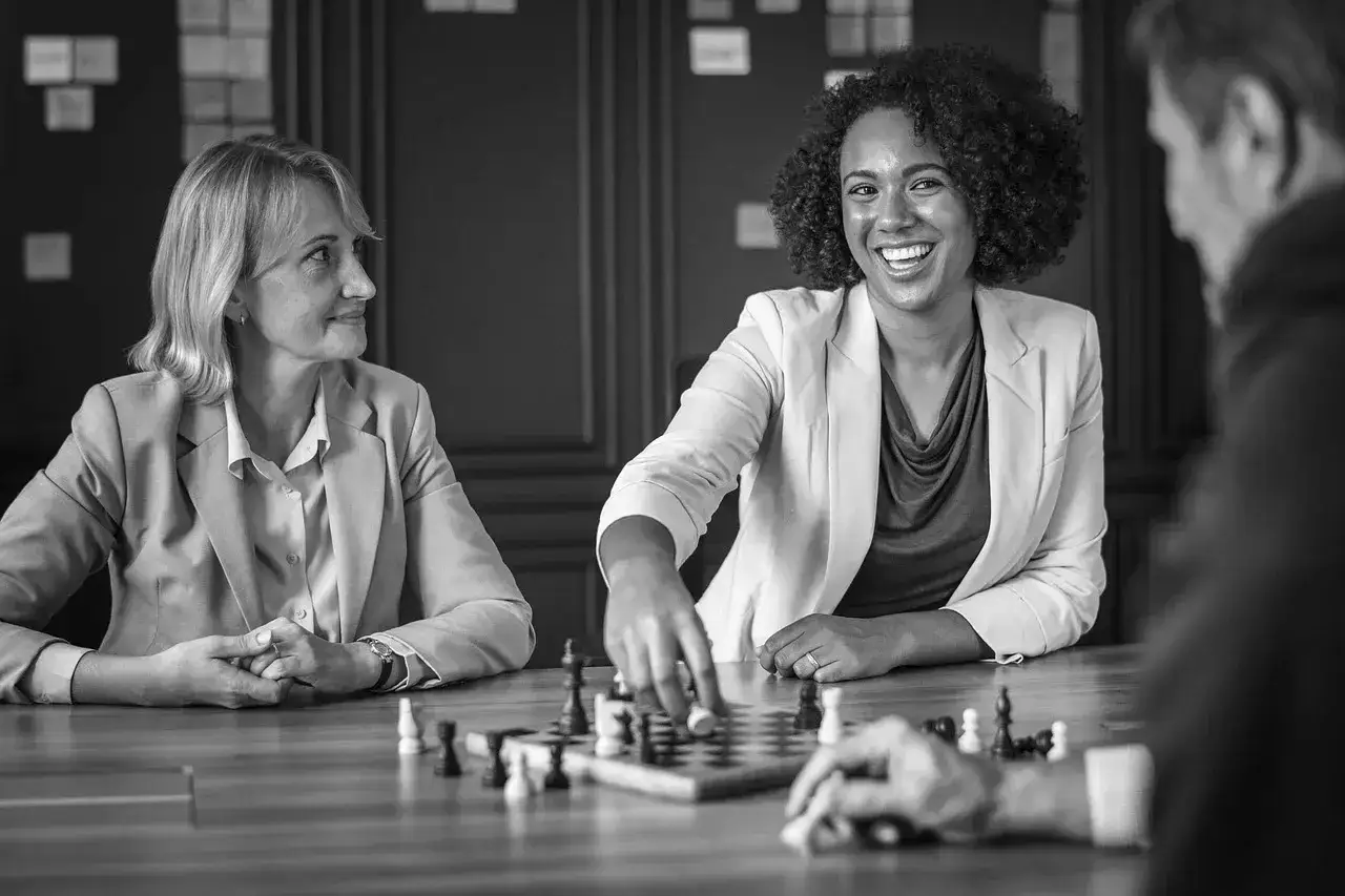 Kvinnor och m&auml;n spelar schack, en strategisk aktivitet som kan liknas vid UGL utbildning f&ouml;r att utveckla ledarskap.