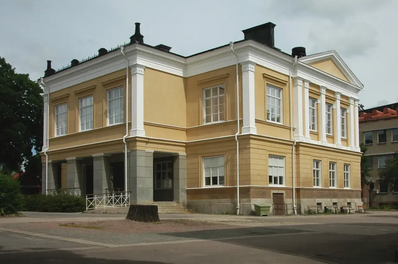 Gul byggnad med kolonner och vita detaljer, liknande Rudbeckianska gymnasiet.