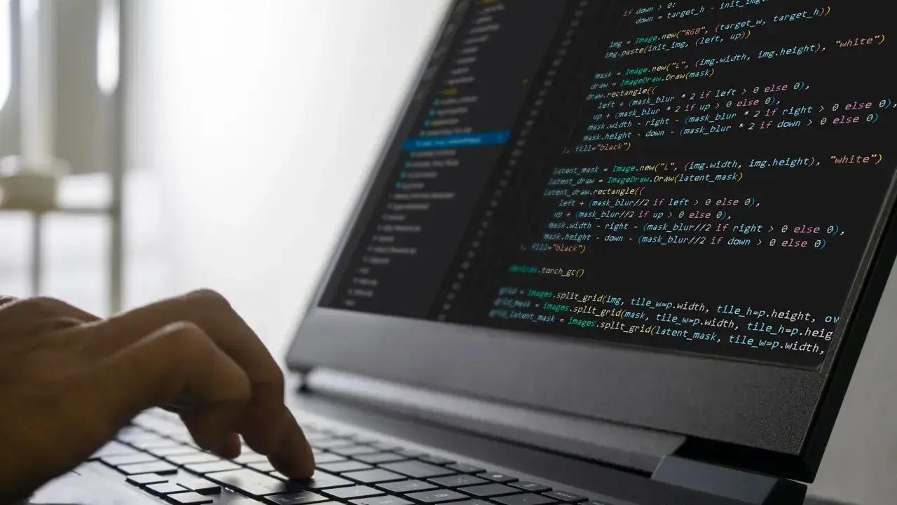 Person skriver kod p&aring; en laptop, en bild som symboliserar systemutvecklare utbildning distans.