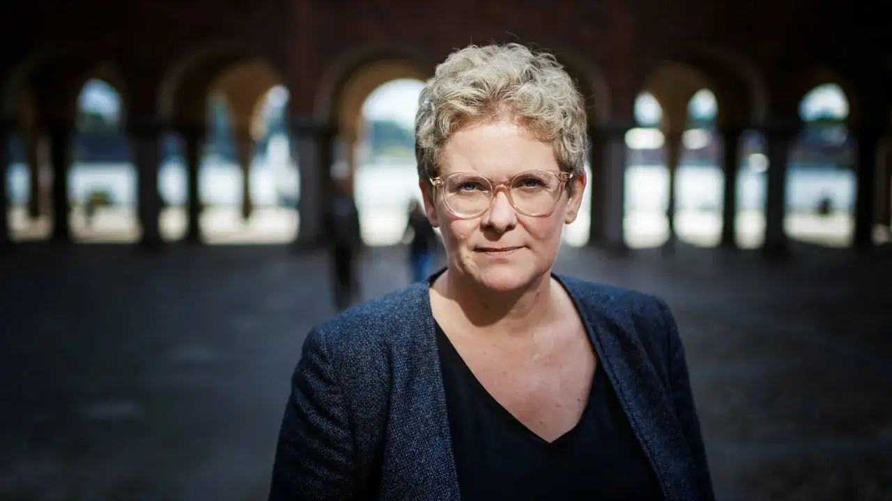 En kvinna med kort, lockigt h&aring;r och glas&ouml;gon, kl&auml;dd i kavaj, framst&aring;r som en erfaren management konsult.