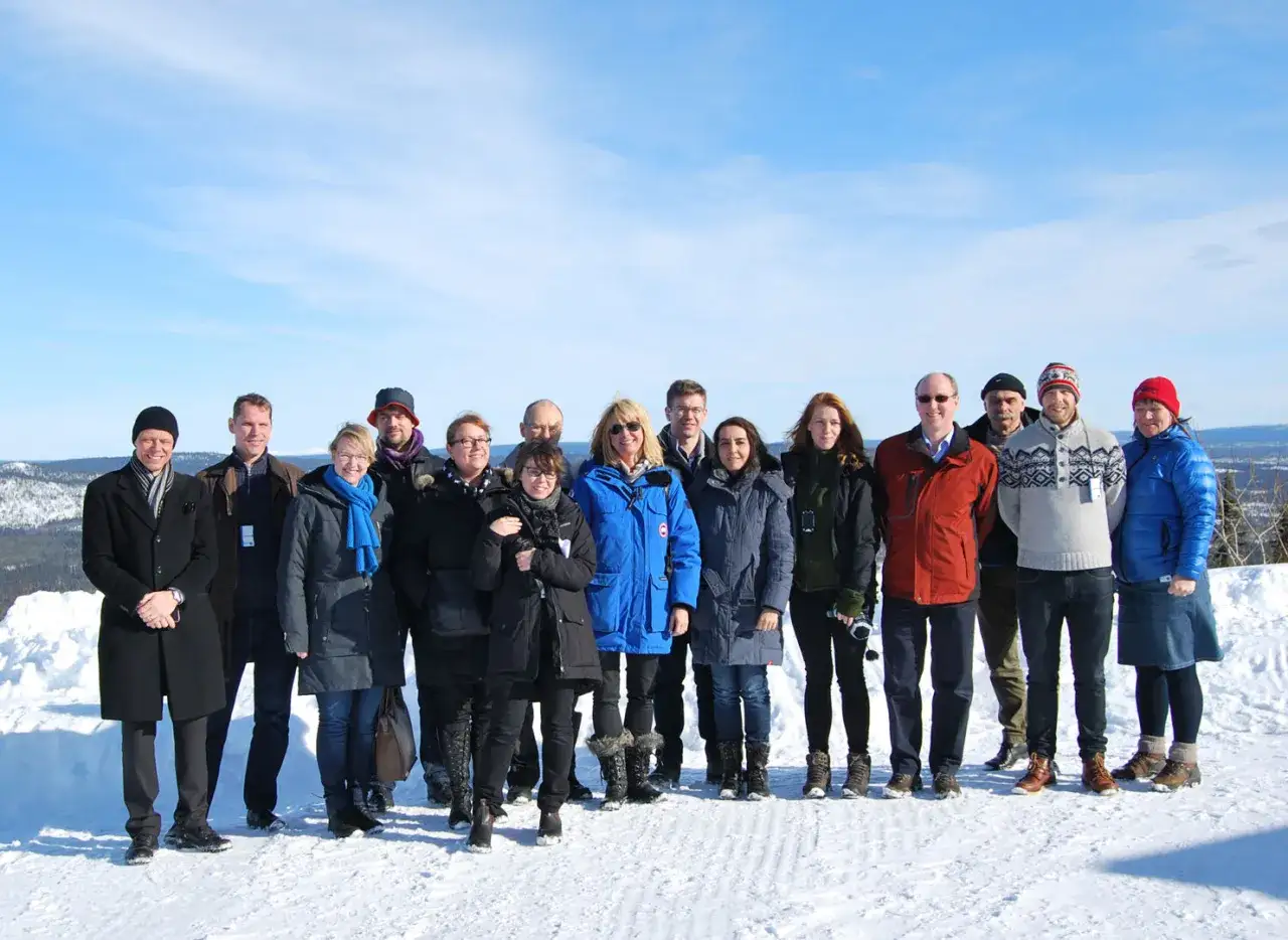Gruppbild p&aring; en sn&ouml;t&auml;ckt kulle med en grupp m&auml;nniskor i vinterkl&auml;der. De bes&ouml;ker troligen rymdgymnasiet Kiruna.