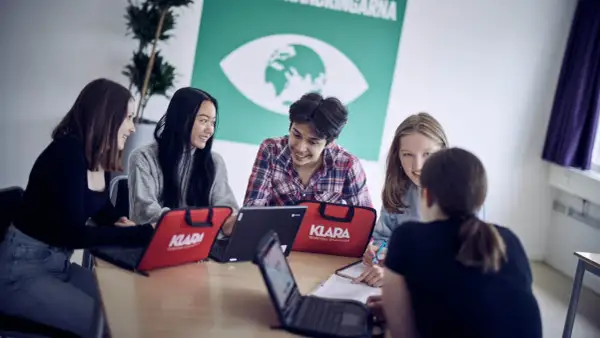 Elever på Klara Norra gymnasium samarbetar kring laptops.